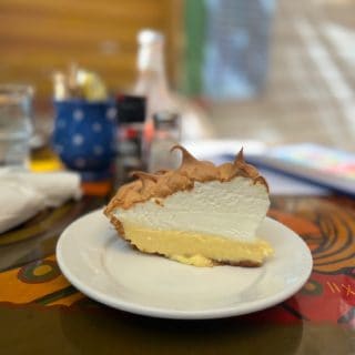 A slice of puffy meringue style key lime pie on a plate at Blue Heaven restaurant in Key West