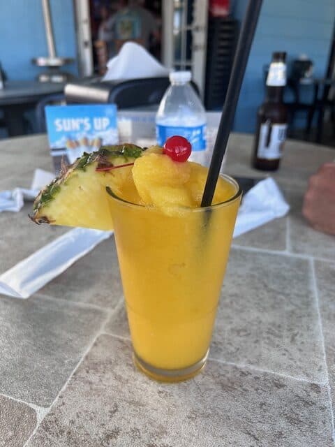 Orange tropical drink in a glass with a straw