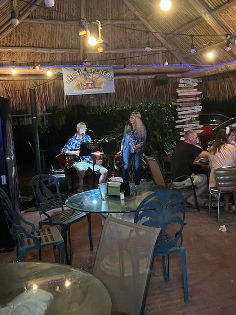 Two performers singing in a tiki bar.