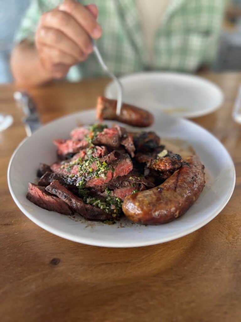 plate full of steak, sausage and chicken