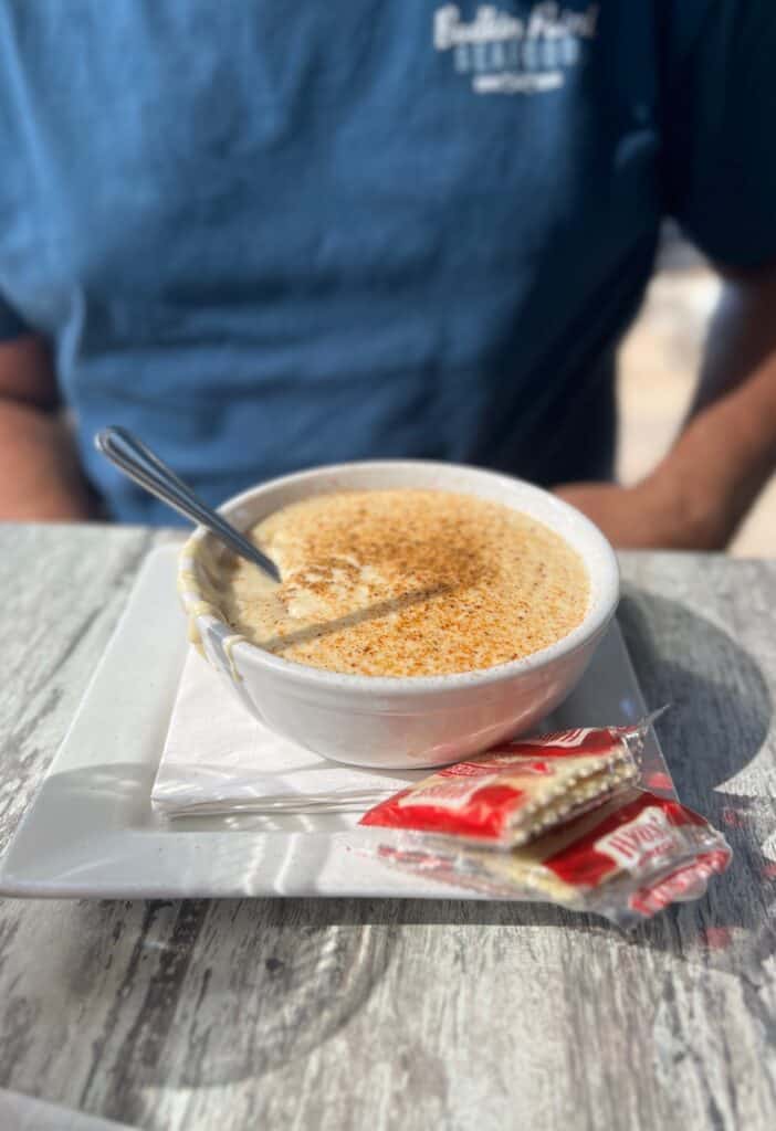 Bowl of cream of crab soup with crackers on the side and a sprinkle of Old Bay